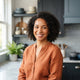 A professional portrait of a smiling woman in a bright, modern kitchen setting.
