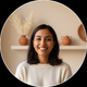 Headshot of a smiling South Asian woman, late 20s, with natural lighting and a warm cream background.